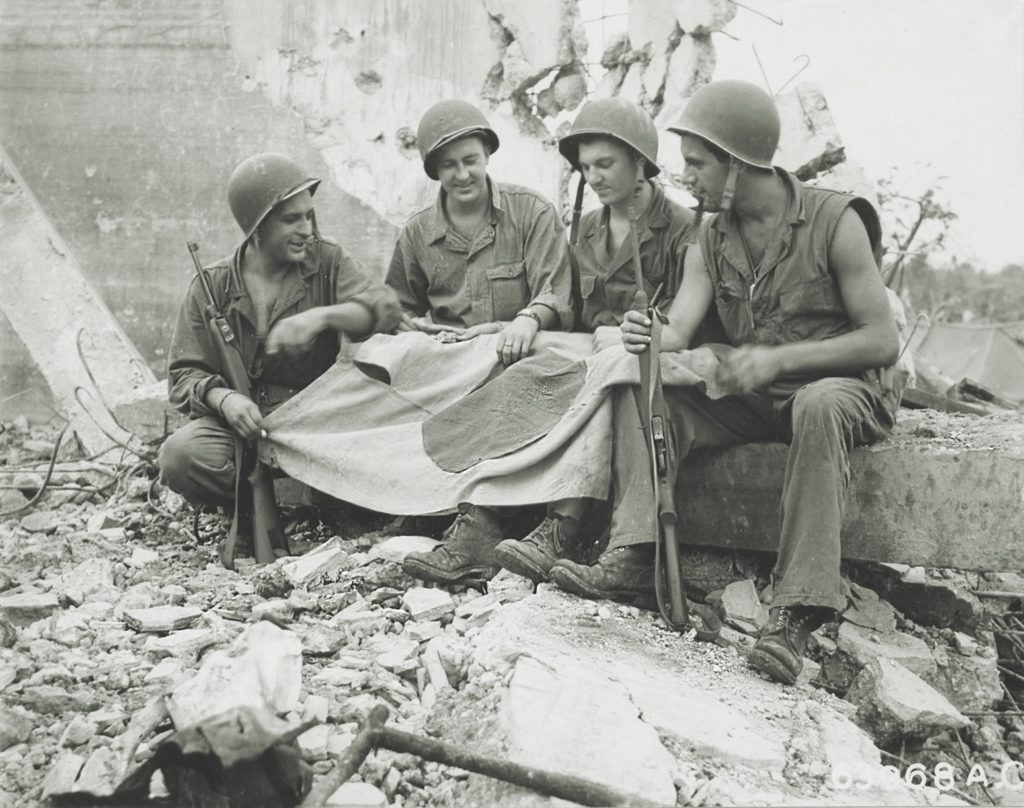 Troops on Angaur gather around a captured flag. Although doomed, the Japanese were nonetheless a deadly enemy to the end. (U.S. Air Force/National Archives) 