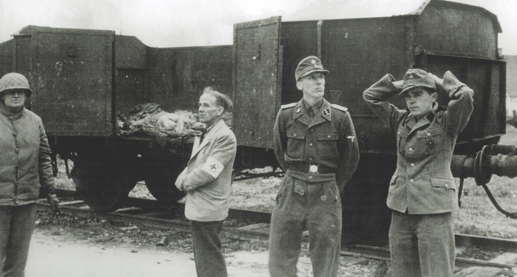 The camp commandant, SS Lieutenant Heinrich Wicker (second from right, top), surrendered the camp and its guards to 42nd Division commander Brigadier General Henning Linden (far left, top). Despite the seemingly peaceful transfer, G.I.s reacted with violence at what they saw there. (Hum Images/Alamy)
