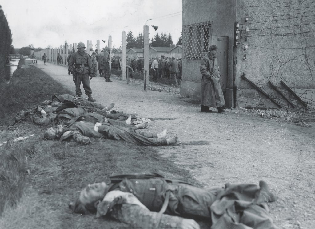 Fallen SS guards lie outside a camp guard tower after one American started firing and others followed. Eyewitness accounts differed on whether the Germans had made any threatening gestures. (National Archives)