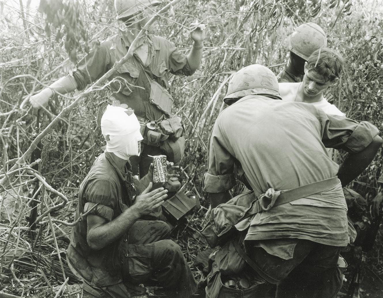Members of Delta Company discuss their battles and receive treatment for the wounds they received during the fighting near Tam Ky on Aug. 12, 1969. A box of Cracker Jack from back home aids in one soldier’s recovery. / ProQuest photo, Getty Images