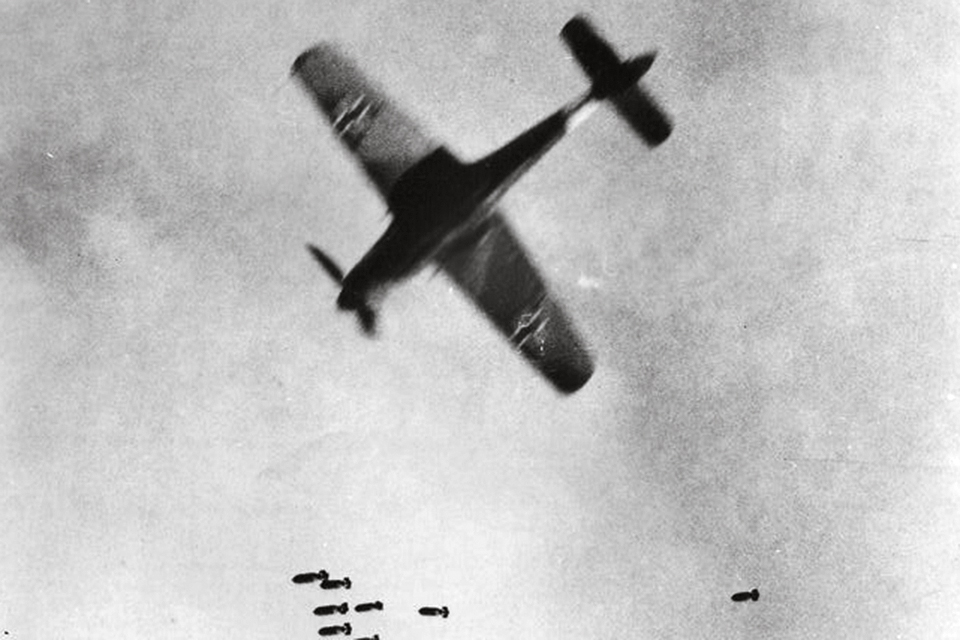 A long-nosed FW-190D makes a dash through the bomber stream and a cascade of falling bombs. (National Archives)
